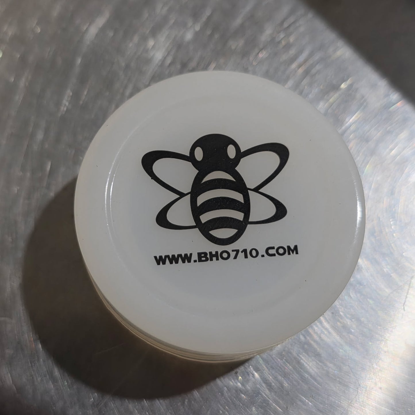 White container with black bee logo and website text