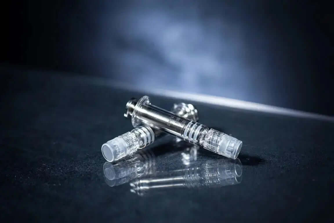 Syringes for extracts Luer Lock & Oral on a reflective surface, showcasing precision design and functionality.