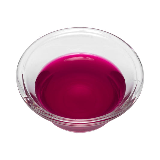 Clear glass bowl filled with beet dye on a white background