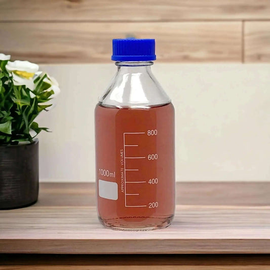1L laboratory borosilicate media bottle on a wooden shelf, featuring blue cap and measurement markings, essential for researchers and labs.