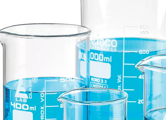 Industrial borosilicate glass beakers for lab use with blue liquid.